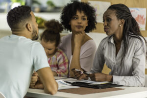 Family with child talking to the girls teacher